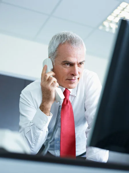 Volwassen zakenman aan de telefoon in het kantoor — Stockfoto