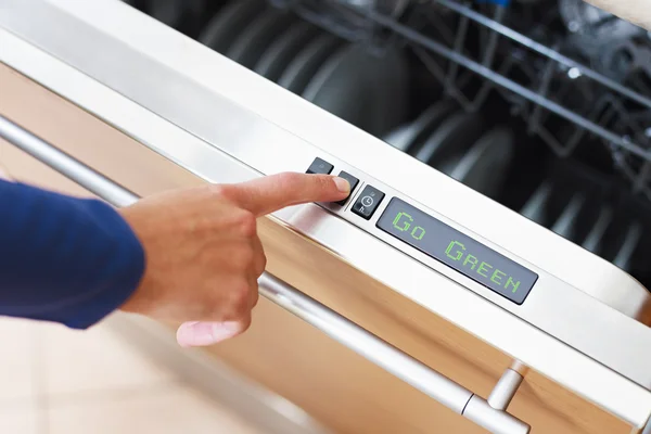 Mulher pressionando botão economizador de energia na máquina de lavar louça — Fotografia de Stock