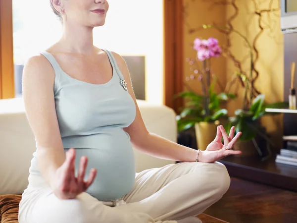 Hamile kadın evde yoga yapıyor. — Stok fotoğraf