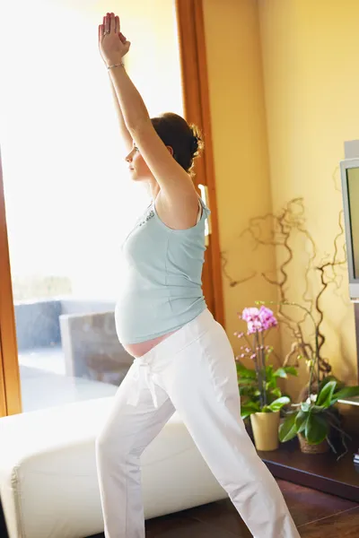 Беременная женщина занимается йогой дома — стоковое фото