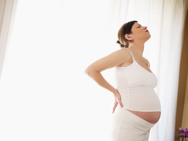Беременная женщина с болями в спине — стоковое фото