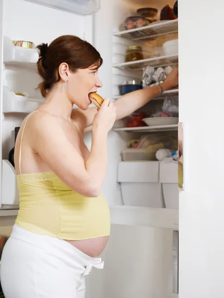 Беременная женщина ест сэндвич — стоковое фото
