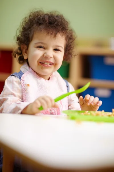 Little girl eating lunch in kindergarten — Stock Photo, Image