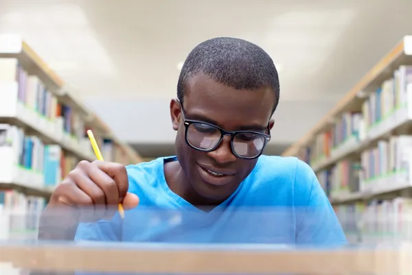Mladý africký muž studovat v knihovně — Stock fotografie