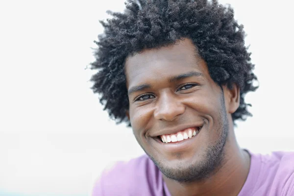 Молодой африканский мужчина улыбается в камеру — стоковое фото
