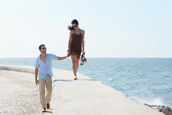 Jonge man en vrouw tijdens de middag lopen in de buurt van de zee — Stockfoto