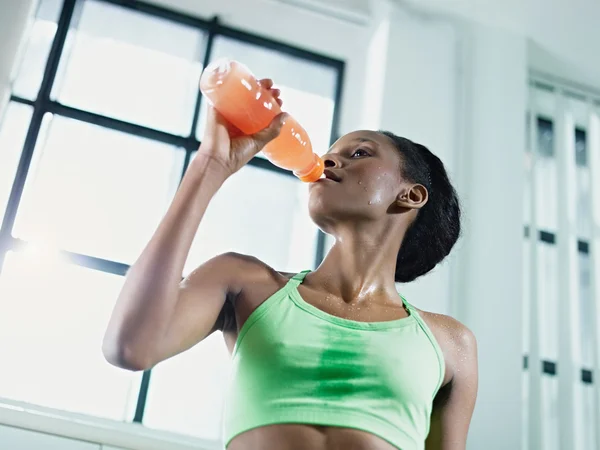 Afrikaanse vrouw in sportschool drinken energiedrank — Stockfoto