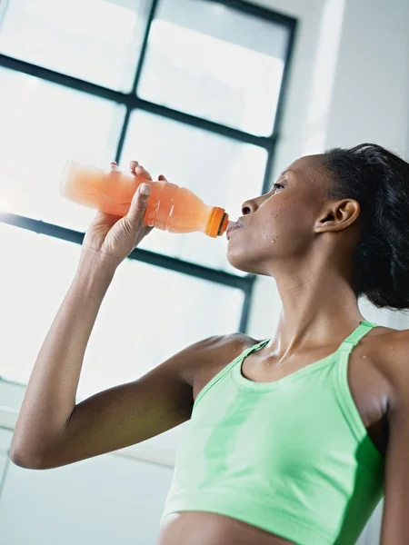 Afrikansk kvinna i gym dricka energidryck — Stockfoto