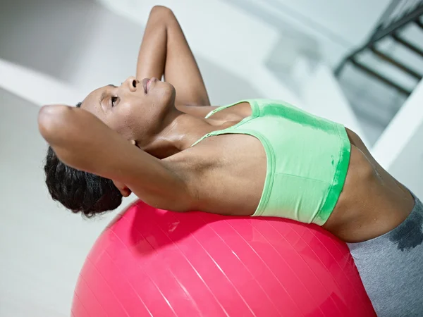 Mujer africana haciendo series de abdominales en el gimnasio — Foto de Stock