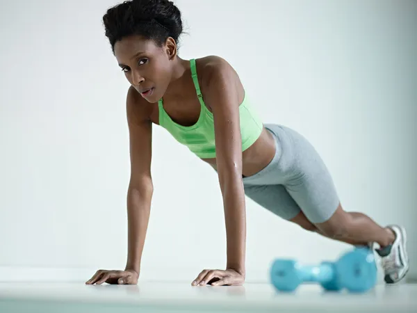 Africano mulher fazendo série de flexões no ginásio — Fotografia de Stock