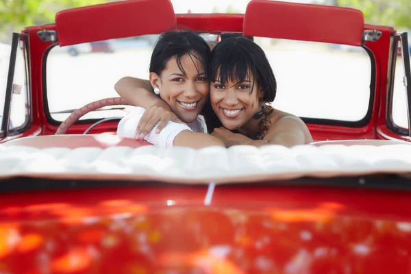 Mooie tweelingzusjes knuffelen in cabriolet auto — Stockfoto