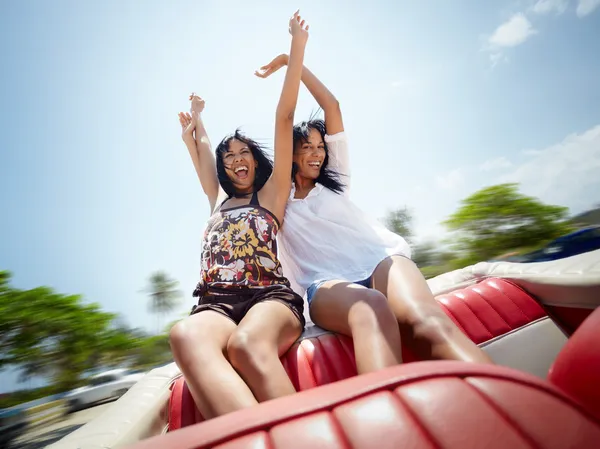 Beautiful twin sisters having fun in cabriolet car — Stock Photo, Image