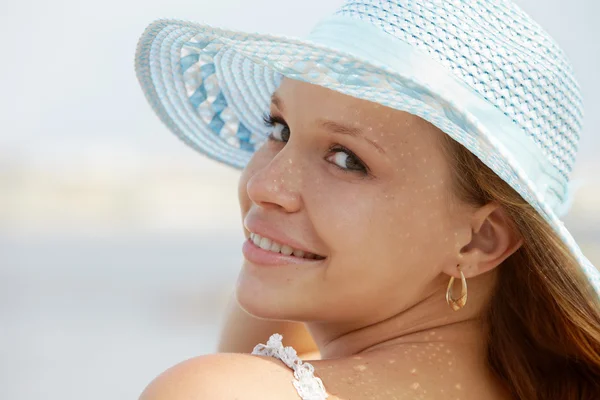 Vrouw in stro hoed glimlachen op camera — Stockfoto