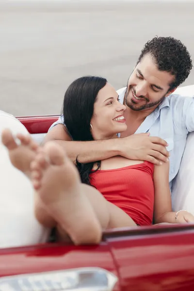 Hombre y mujer hermosa abrazándose en coche cabriolet — Foto de Stock