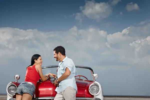 Hombre y mujer hermosa apoyándose en el coche cabriolet — Foto de Stock