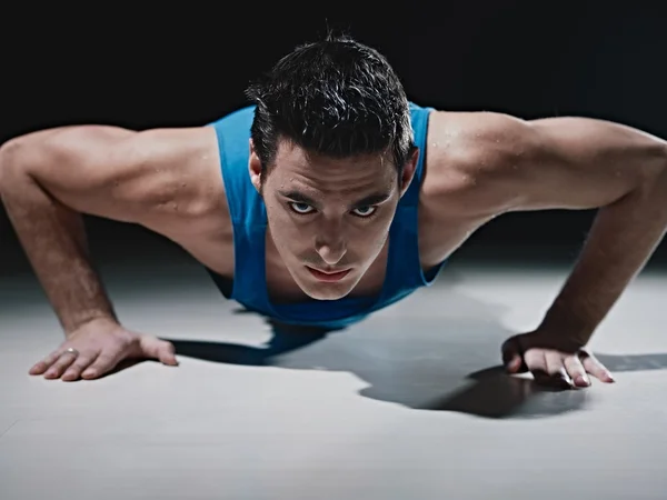 Man doing push-ups on black background — Stock Photo, Image