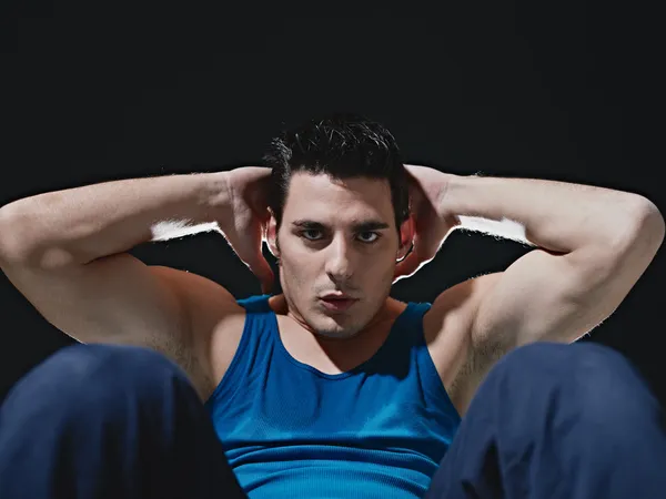 stock image Man doing series of sit-ups on black background