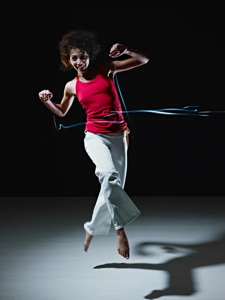 Латиноамериканка танцует и прыгает со светом — стоковое фото