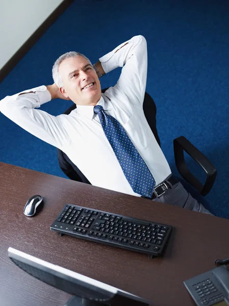 Mature businessman relaxing in office — Stock Photo, Image