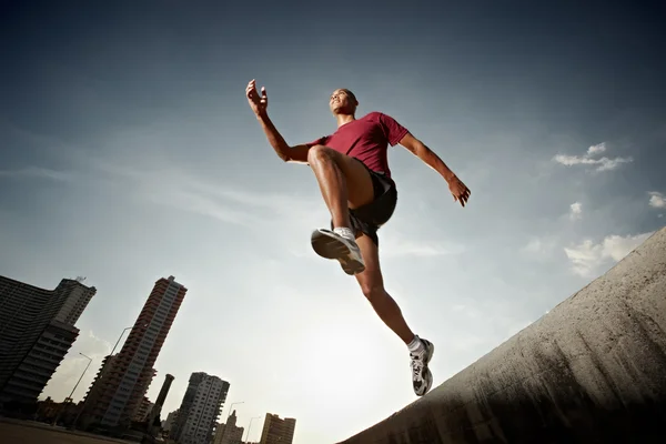 Homem hispânico correndo e pulando de uma parede Fotos De Bancos De Imagens