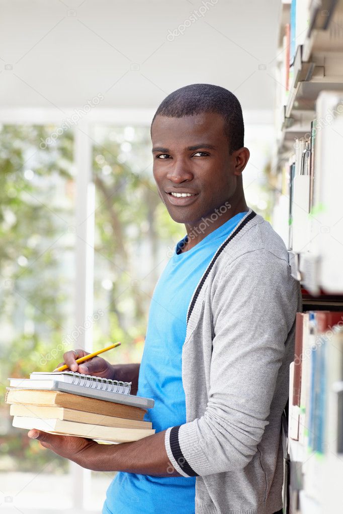 Young african man smiling in library