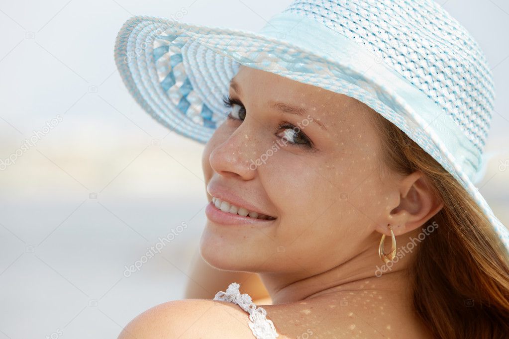 Woman in straw hat smiling at camera