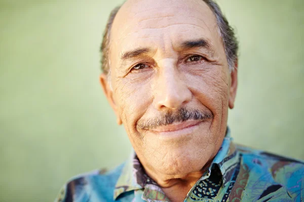 Vecchio latino uomo sorridente alla macchina fotografica — Foto Stock