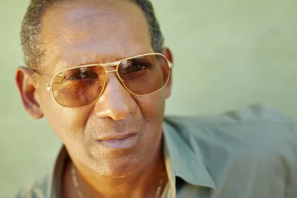 Homem idoso sério com óculos de sol olhando para a câmera — Fotografia de Stock