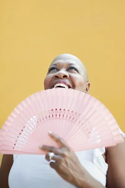 Volwassen Afrikaanse vrouw met ventilator, glimlachend — Stockfoto