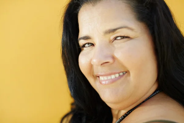 Mature hispanic woman smiling at camera — Stock Photo, Image
