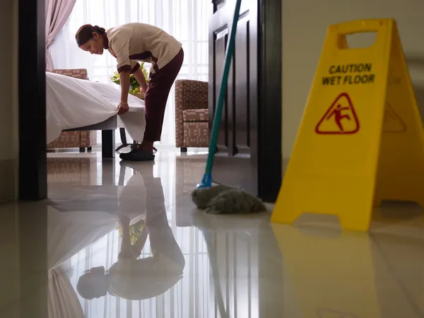 Empregada doméstica no trabalho e limpeza em quarto de hotel de luxo — Fotografia de Stock