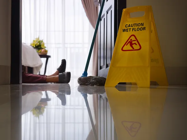 Maid slipped on wet floor and laying down — Stock Photo, Image