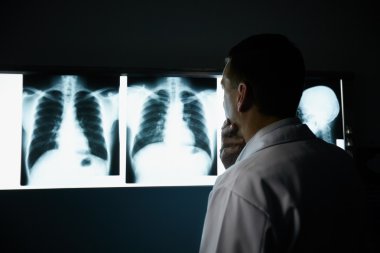 Doctor working in hospital during examination of x-rays clipart