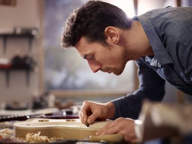 Italian artisan working in lutemaker workshop clipart
