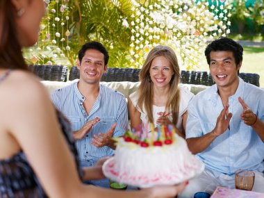 Friends with cake at birthday party clipart