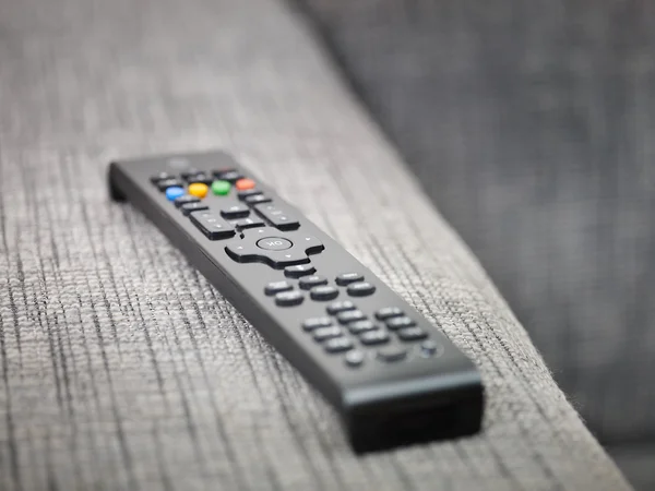 TV controle remoto no sofá — Fotografia de Stock