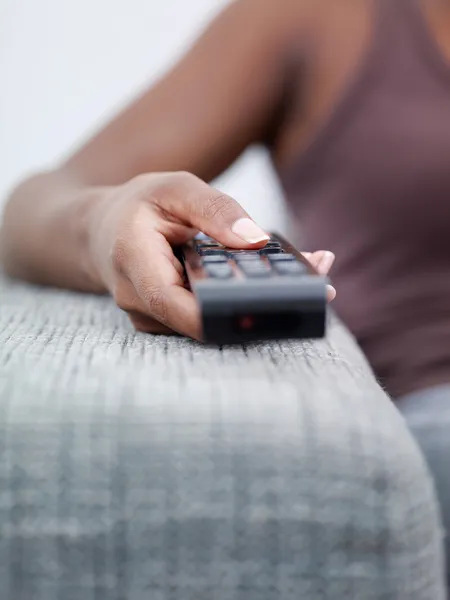 Žena držící dálkové ovládání a sledování televize — Stock fotografie