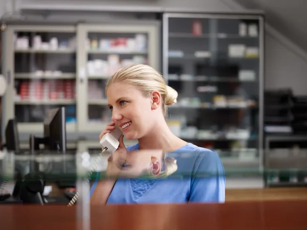 Klinik ve telefonla konuşan hemşire olarak çalışan kadın — Stok fotoğraf