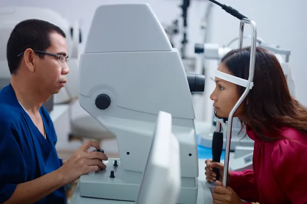 Exame de visão na clínica com médico asiático e paciente do sexo feminino — Fotografia de Stock