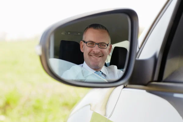 Empresário no carro sorrindo para a câmera — Fotografia de Stock