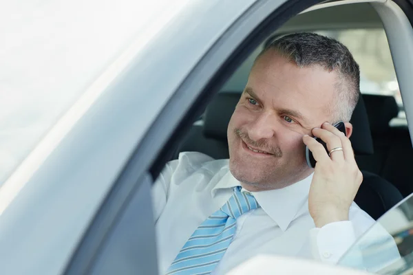 Affärsman i bilen pratar i mobiltelefon — Stockfoto