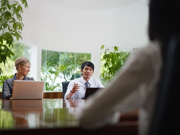 Uomo e donna d'affari che parlano in sala riunioni — Foto Stock