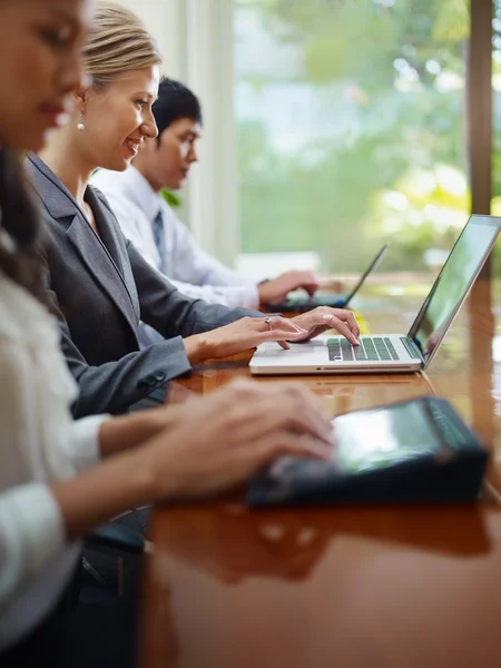 Ο άνθρωπος των επιχειρήσεων και γυναίκες πληκτρολογώντας στον υπολογιστή κατά τη διάρκεια συνάντησης — Φωτογραφία Αρχείου