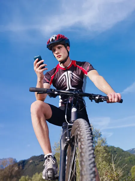年轻的人有电话骑山地自行车 — 图库照片