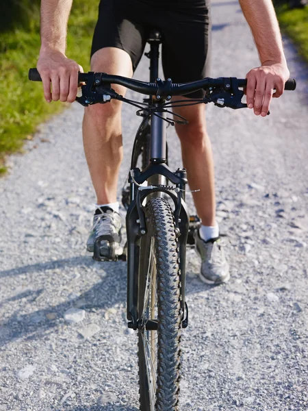 Hombre joven entrenando en bicicleta de montaña — Foto de Stock