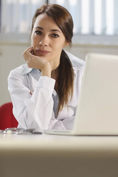 Szczęśliwa kobieta lekarz działa z komputera w studio — Zdjęcie stockowe