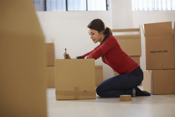 Kaukasierin zieht mit Kisten in neue Wohnung — Stockfoto
