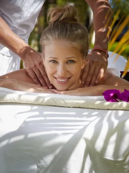 Happy young woman smiling during massage in spa — Stock Photo, Image