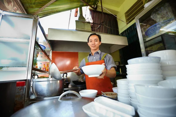Homem trabalhando como cozinheiro na cozinha do restaurante asiático — Fotografia de Stock