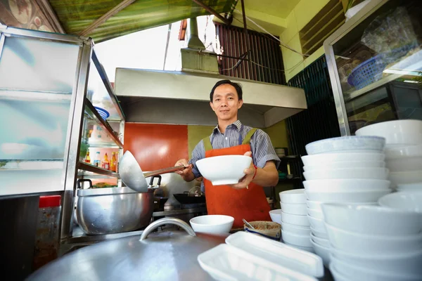 Hombre trabajando como cocinero en cocina de restaurante asiático — Foto de Stock